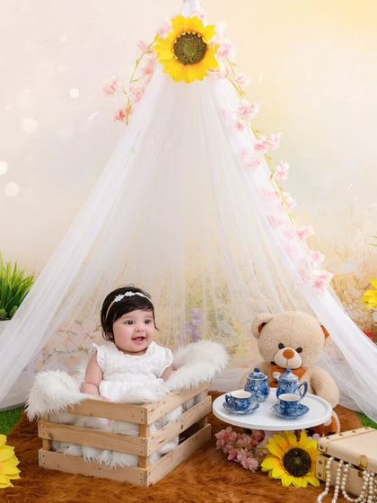 This adorable four-month-old baby girl is all giggles and cuteness in our sunny, sunflower-themed tent setup.