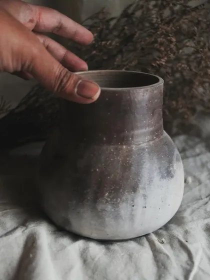 I call this pit-fired vase 'Stardust'. I achieved this subtle, speckled effect by throwing sawdust onto the piece when it was still hot from the fire. It’s a beautiful, earthy piece for dry arrangements.