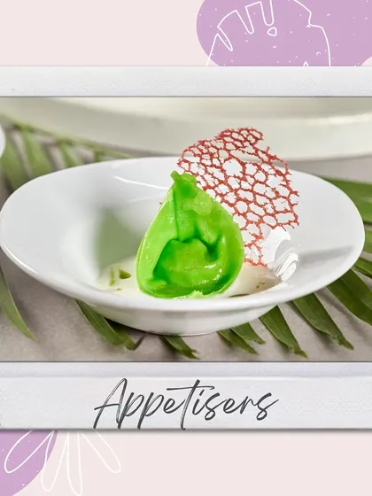 A vibrant green dim sum with a delicate coral tuile, plated on a white dish. This appetizer is a perfect example of our culinary creativity and artful presentation.