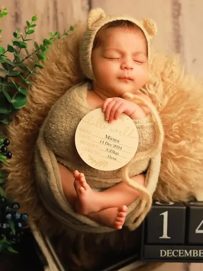 A personalized birth announcement photo for baby Miraya. We incorporate custom props like this wooden "hello world" sign and date blocks to create a unique keepsake that captures all the important details of her arrival.