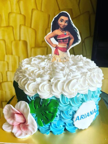 A Moana-themed cake perfect for an adventurous spirit. I used ombre blue and white rosette piping to create the ocean waves, complete with a tropical flower and a Moana topper ready to set sail.