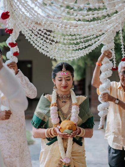 A serene moment during her entrance, holding the traditional coconut.