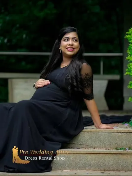 A serene moment captured in our classic black flowy gown. The delicate lace sleeves add a touch of detail, and the simple silhouette is perfect for a graceful and elegant maternity portrait.