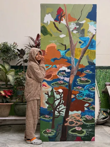 Me with the finished water lily painting. This piece is full of color, texture, and symbolism, making it a deeply personal and vibrant statement for my client's home.