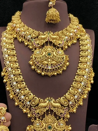 I am in awe of the grandeur of traditional South Indian temple jewellery. This complete rental set, featuring a short necklace, a long haar, and matching jhumkas, is handcrafted with intricate peacock motifs for an authentic and royal look.