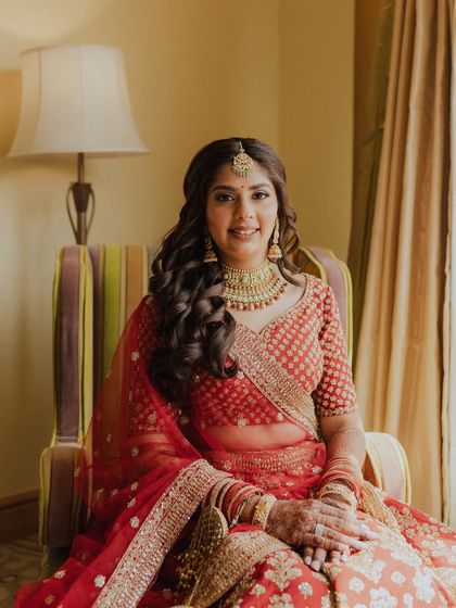 A full seated portrait, showing how the makeup complements her entire bridal ensemble.