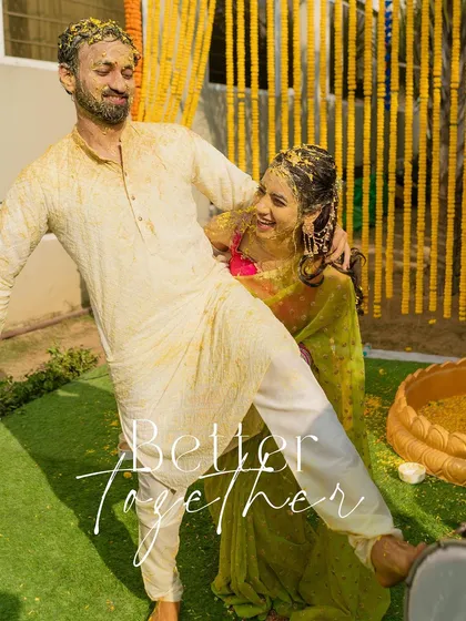 A fun-filled shot of the couple, covered in haldi, posing together after the ceremony.