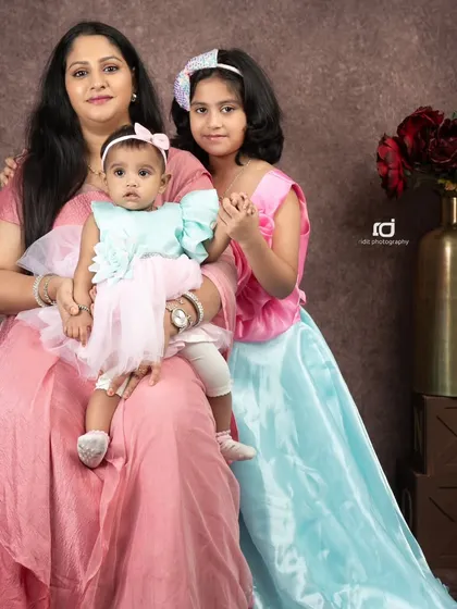 A mother's love. Here, a mom sits with her two daughters, the older one holding her hand and the baby on her lap, showing the beautiful connection between them.