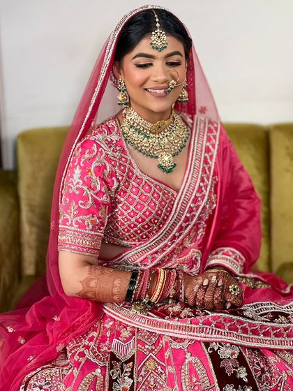 This bride's smile lights up the room. Her hair is styled in a classic bun, allowing her beautiful jewelry and outfit to shine.