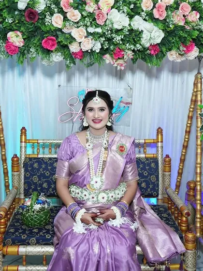 The mom-to-be seated on the decorated swing, looking radiant in her full set of custom floral jewellery.