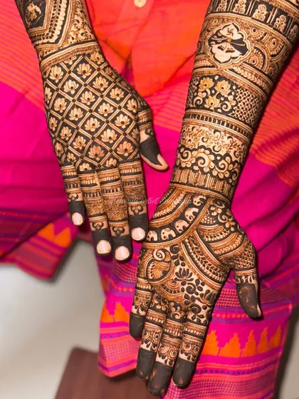 A classic grid pattern on the back of the hands complements the detailed floral and elephant motifs on the front. This design offers a beautiful contrast between geometric and organic elements.