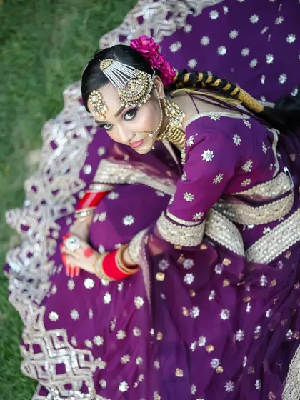 An aerial shot of the bride, showcasing her elaborate lehenga and braided hairstyle. You will learn to think about the complete visual presentation, not just the face.