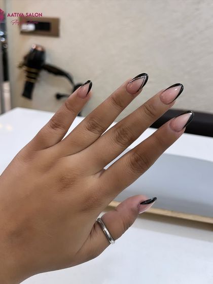 The almond shape of these nails perfectly complements the sharp lines of the black V-tip French design.