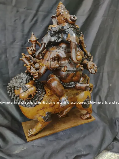 This side-angle of the Heramba Ganapati wax model shows the dynamic relationship between the deity and his lion vahana (vehicle), a key feature of this powerful form.