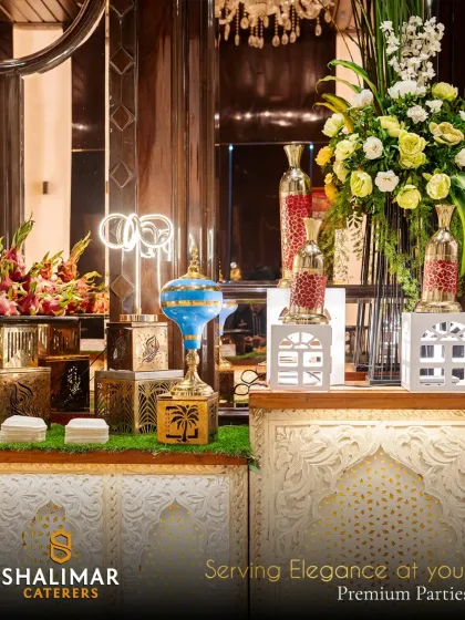 We serve elegance at your premium parties. This stylish buffet counter, featuring ornate risers and a modern neon sign, becomes a central point of attraction for guests.