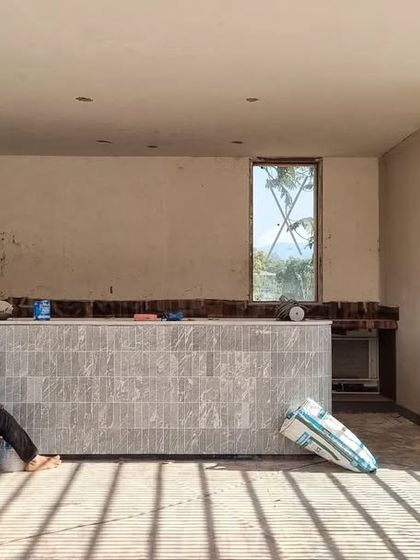 An artisan puts the finishing touches on a custom-designed bar at our Alibaug project. The bar front is clad in vertically laid marble tiles, a detail we refined through on-site collaboration.