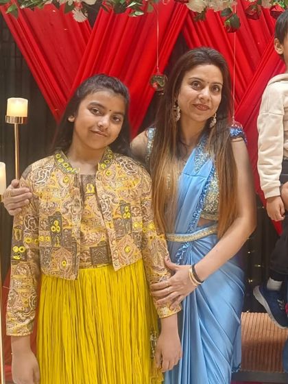 A client with her family, wearing our light blue ready-to-wear saree. Her daughter is also dressed in a custom yellow jacket and dress set from our kids' collection.