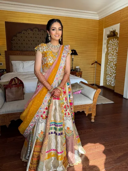 A full view of the bride in her room, with the sunlight illuminating her beautiful outfit.
