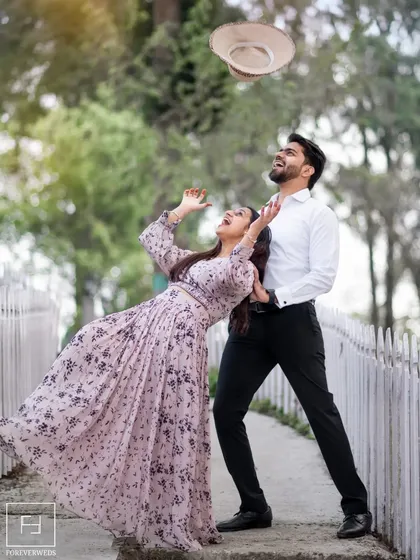 Let's have fun with it. A pre-wedding shoot should be full of laughter and playful energy. This spontaneous moment, with Arihant tossing his hat as Ishu laughs, perfectly captures the lighthearted and joyful side of their relationship.