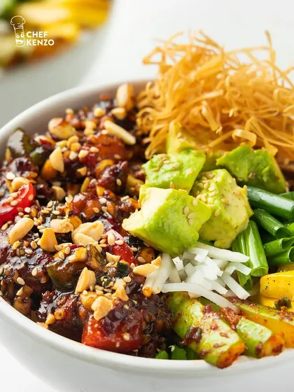 Look at the details in this bowl. Creamy avocado, crunchy peanuts, and a rich sauce over assorted veggies and protein make every bite an adventure.