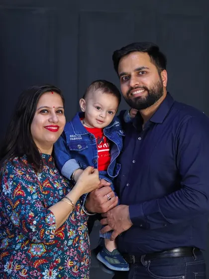 A simple and beautiful family of three portrait. Their coordinated outfits and happy smiles make this a perfect example of a classic studio photo.