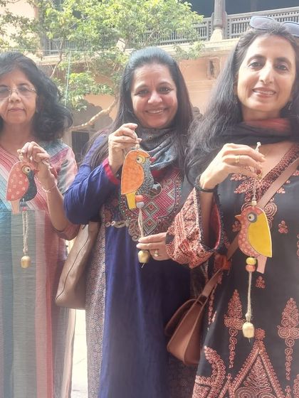 It's always wonderful to see friends enjoying my work. Here are three lovely ladies at the Bhopal Potter's Market, each holding one of my colorful bird chimes.