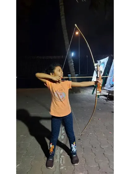 A young girl aiming with determination during an evening practice. It's inspiring to see our students so dedicated.