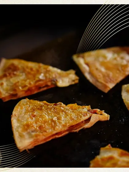 Our Tuscan Quesadillas are grilled to golden-brown perfection. These triangular bites are filled with savory ingredients, making for a delicious and easy-to-eat option at any event.