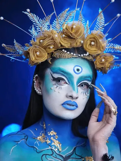The complete look, featuring gold leaf details on the body and an intense, captivating gaze. This is avant-garde makeup at its finest.