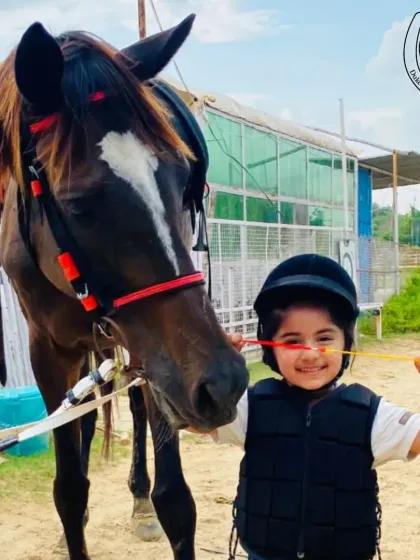 The smile says it all. We ensure our youngest riders, starting from age two, feel safe and confident as they meet our gentle horses for the first time. It's about building trust and having fun.