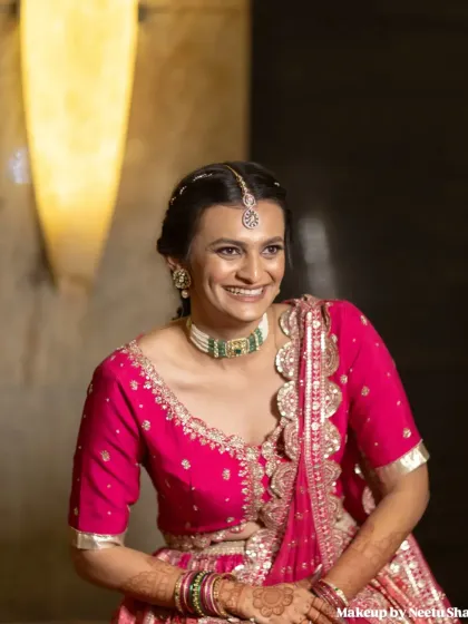 A happy bride ready for her Garba night. The vibrant pink lehenga is perfect for twirling, and the makeup is kept bright and festive.