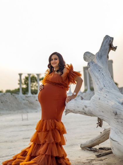 An outdoor shot of our Bronze gown in a rustic, desert-like setting. The earthy color of the dress blends beautifully with the natural landscape.