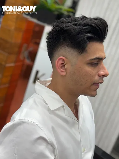 A perfect example of a high-volume style with a sharp fade. This look is all about texture and height on top, contrasted with clean, faded sides for a modern finish.