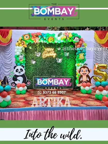 Into the wild for a 5th birthday! This jungle theme features a full balloon arch over a grass backdrop, complete with fun animal cutouts and the birthday girl's name in light-up letters.