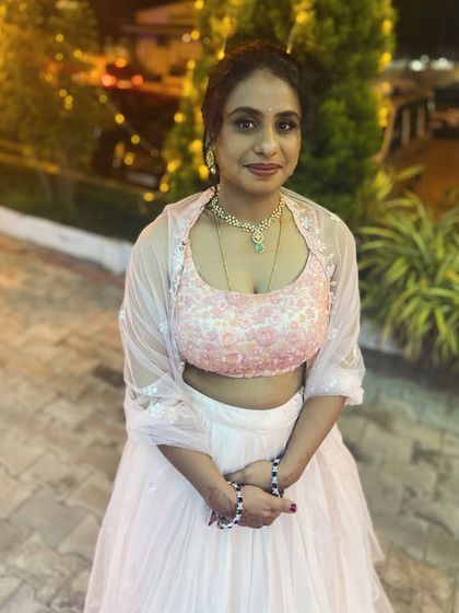 A pretty and modern guest look. The client is wearing a lovely pink and white lehenga, and I created a fresh makeup look with a stylish ponytail.
