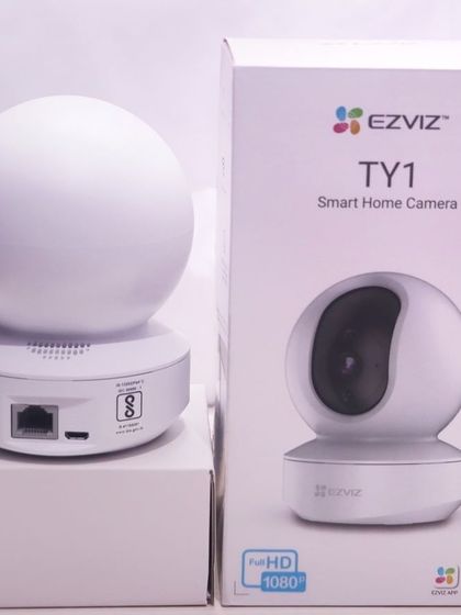 The EZVIZ TY1 camera next to its packaging. This model provides full HD 1080p resolution and a microSD card slot for local storage up to 256 GB.
