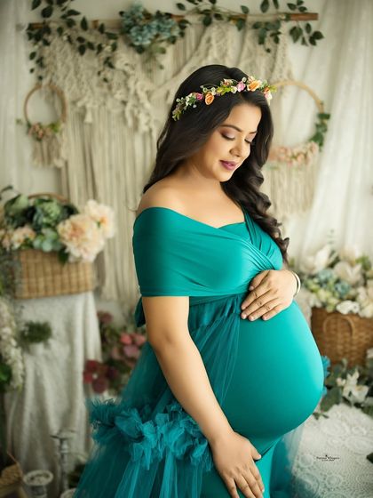 A close-up portrait focusing on the beautiful twin baby bump. The mother-to-be cradles her belly, her expression full of love and wonder.