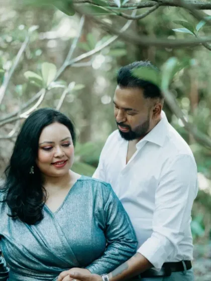 A beautiful portrait of the couple in a natural, green setting. Their coordinated outfits and gentle pose make for a serene and romantic pre-wedding photograph.