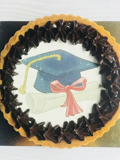 Cap off a major achievement with a sweet reward. This graduation-themed chocolate tart features an edible graduation cap and diploma, framed by rich chocolate swirls, to celebrate academic success.