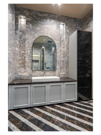 I love playing with patterns and textures. This bathroom combines diagonally striped black and white marble flooring with a grey marble-clad wall and a classic arched mirror for a bold, graphic look.