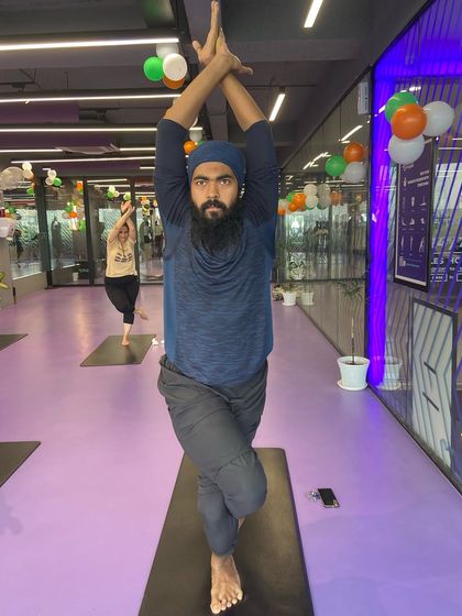 With focused determination, this member holds the Eagle Pose, demonstrating the mental and physical benefits of a regular yoga practice.