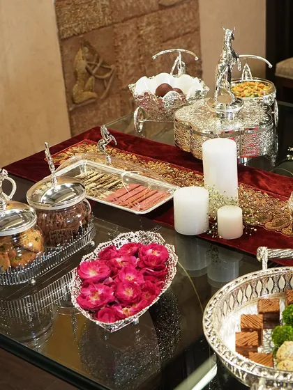 A beautifully arranged festive table featuring a variety of my silver-plated serveware. Each piece, from trays to jars, works together to create a look of opulent celebration.
