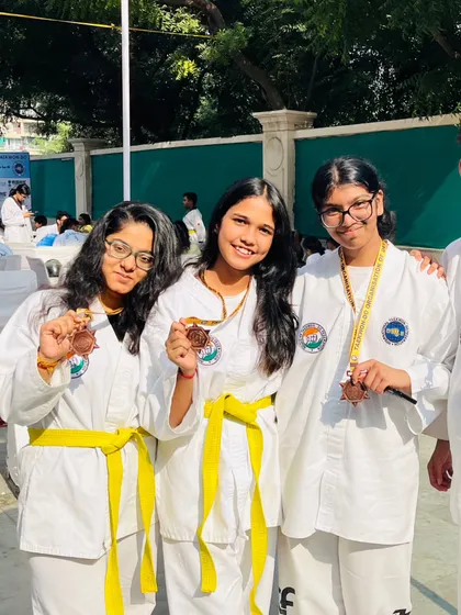 Three of our female students proudly displaying their medals.