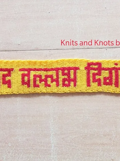 A work in progress shot of a "श्रीपाद वल्लभ दिगंबरा" toran, showing the lettering panel before the decorative hangings are attached.