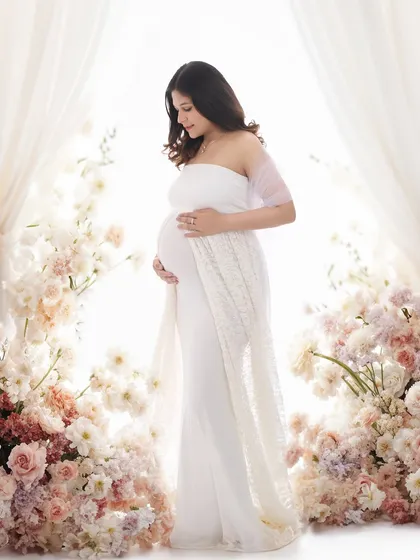 Surrounded by a sea of delicate flowers, this portrait embodies a bright and dreamy aesthetic. We use soft, high-key lighting to create an ethereal glow, making you the serene center of a floral wonderland.