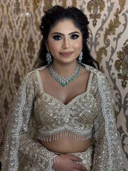 The final portrait of our engagement client. Her makeup is soft yet glamorous, with a focus on the eyes, perfectly complementing her elegant diamond and emerald necklace.