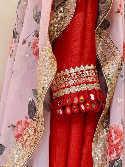 A close-up of the toasted orange Anarkali's sleeve detail, featuring intricate mirror work tassels. It is these small, handcrafted details that make an outfit truly special and unique.