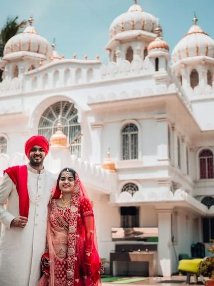 A classic portrait of a Sikh couple standing outside the Gurdwara on their wedding day.