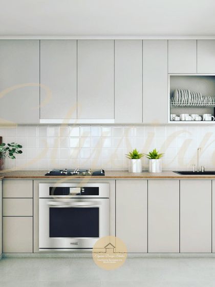 Another view of the neutral-toned kitchen, highlighting the ample storage and dedicated space for an oven. The glossy white subway tiles on the backsplash add texture while being easy to clean.