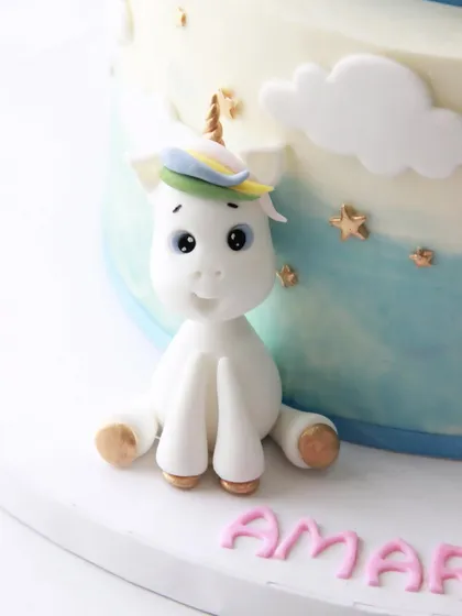 A close-up of the cute, handcrafted unicorn topper from the twins' birthday cake.